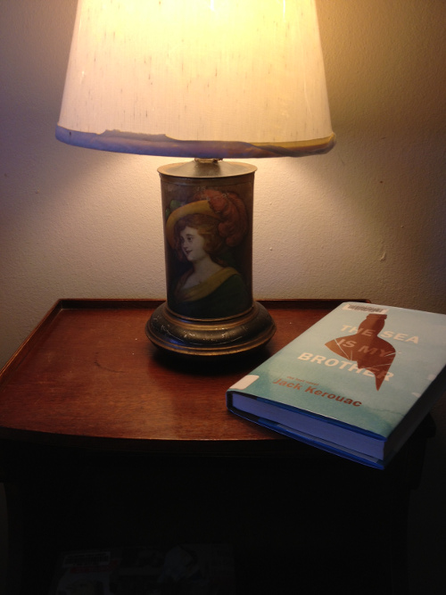 Kerouac's book resting on a nightstand in the dim glow of an antique lamp